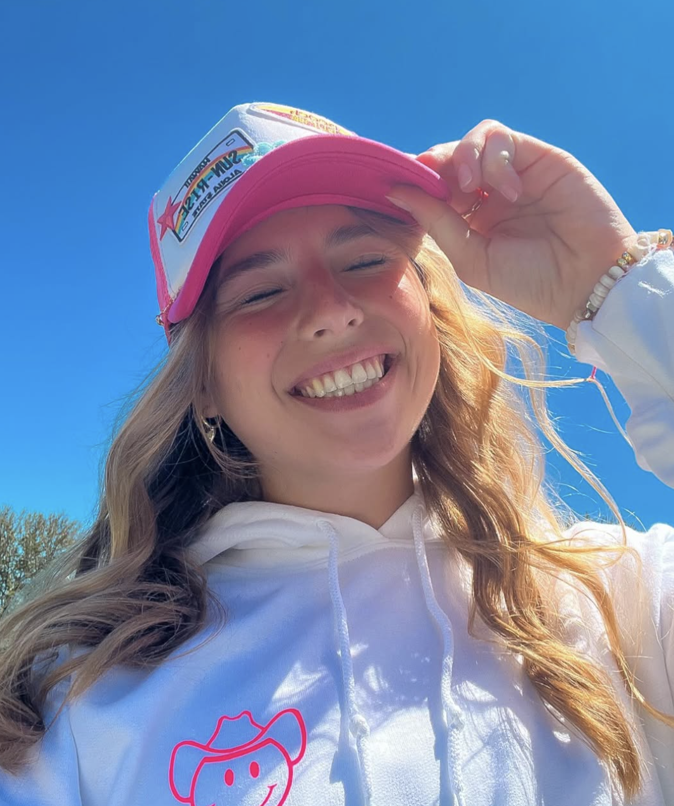 Pink trucker hat and smiley cowgirl hoodie